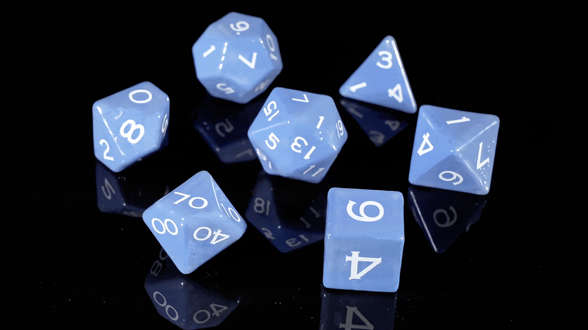 Colorful ceramic polyhedral dice arranged across textured stone