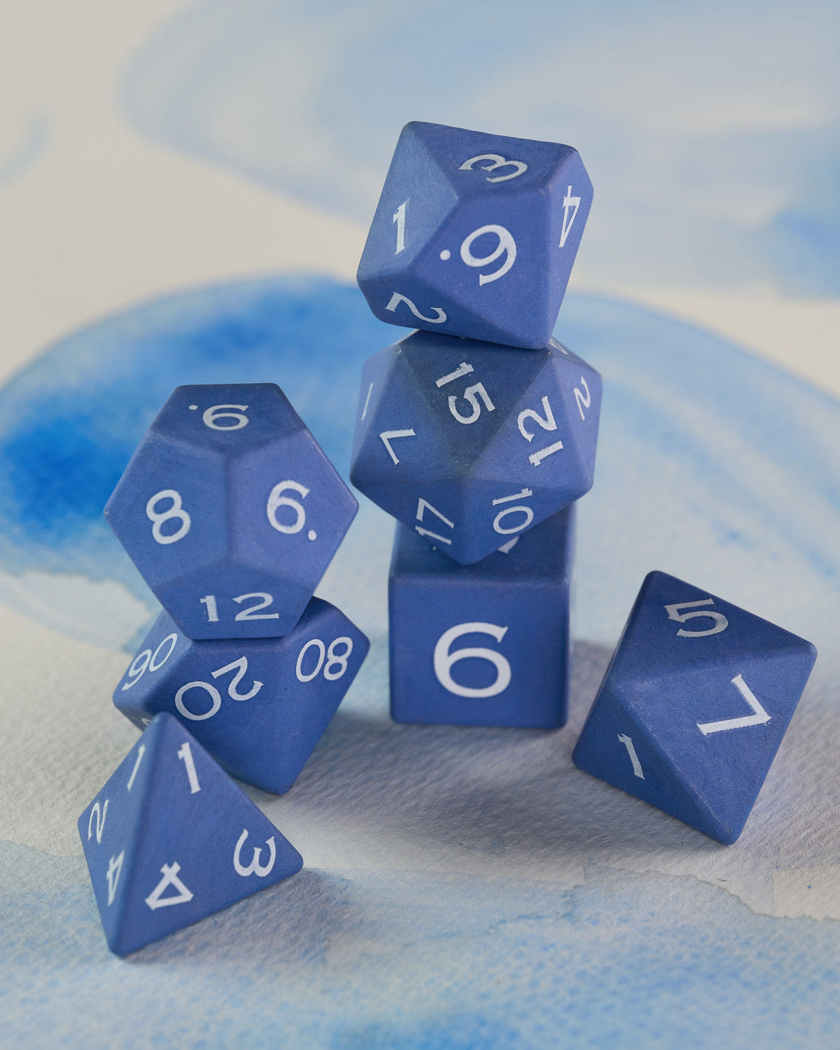 Matte blue ceramic dice with a soft refined surface