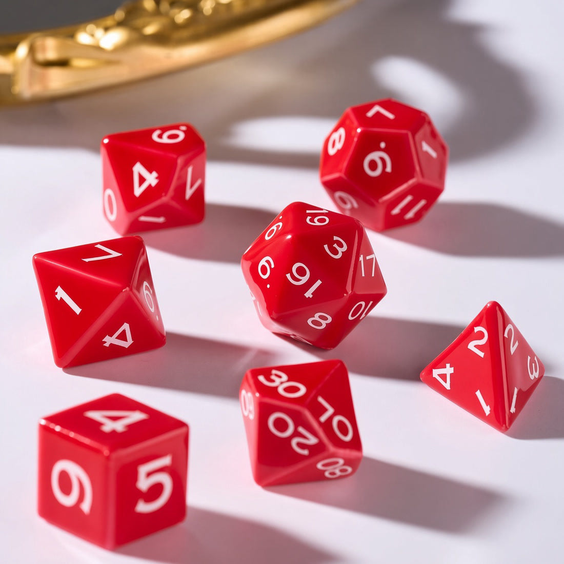 Bright red ceramic polyhedral dice with crisp white numerals