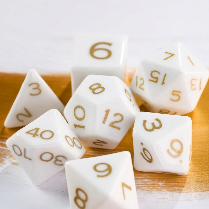 White ceramic polyhedral dice with clear black numerals on a wooden table