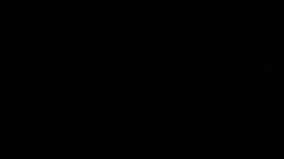 A light sweeps across ceramic dice in darkness